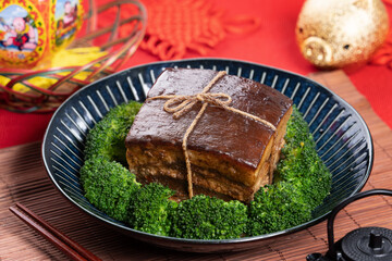 Dong Po Pork meat in a blue plate with broccoli with red background.