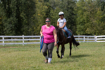 girl on a pony with an instructor