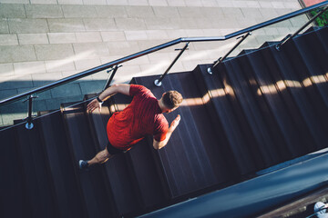 Unrecognizable male jogger running upstairs in modern city