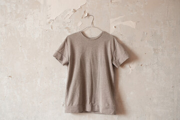 women's gray jacket hanging on a hanger on a white wall close up