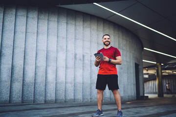 Happy sportsman with tablet resting during break