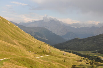 Fototapeta premium Szlak schodzi do doliny pośród zielonych wzgórz, Dolomity, Włochy