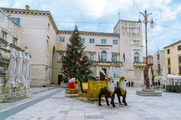 People's square in Zadar decorated for Christmas with walking people. Croatia.