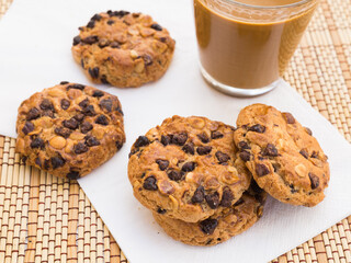 cookies with chocolate and hazelnuts and coffee with milk lie on the table