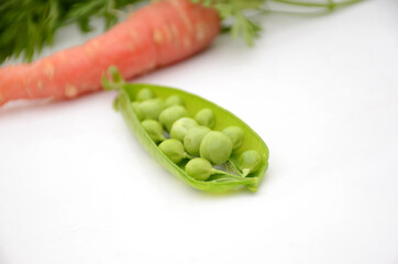 the green ripe peas with red carrot isolated on white background.