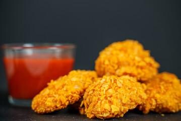 Fried crispy chicken nuggets with ketchup.