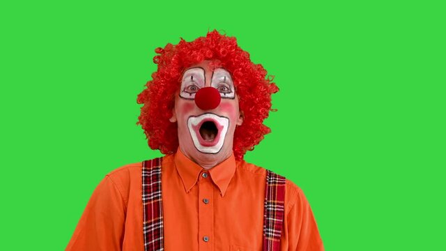 Funny clown being late looking at his watch but takes it easy on a Green Screen, Chroma Key.
