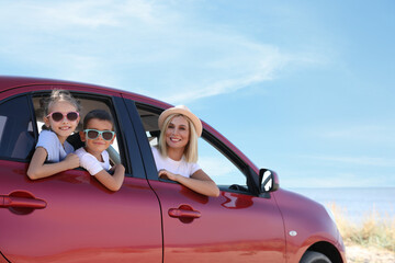 Happy family in car at beach on sunny day