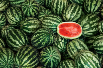 Delicious whole and cut watermelons as background, top view