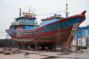 Fototapeta premium Traditional wooden cargo ship (Pinisi) in the Muara Angke harbor, Jakarta, Indonesia