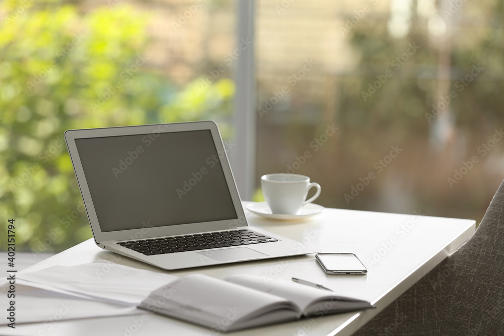 Wall mural modern laptop and supplies on table in office