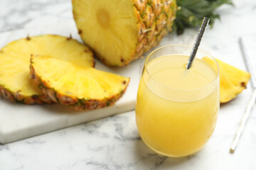Fototapeta na wymiar Delicious pineapple juice and fresh fruit on white marble table