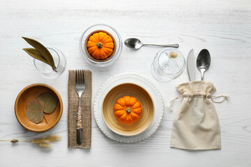 Autumn table setting with pumpkins on white wooden background, flat lay