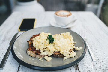 Delicious breakfast with scrambled eggs on bread