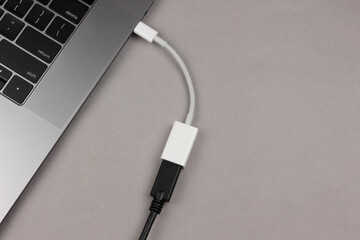 a usb-c  to usb adapter connected to a computer with a usb cable inserted in the other end, a way...