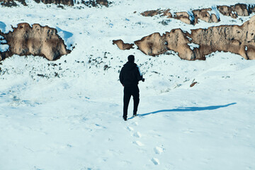 man walks in the snow in nature
