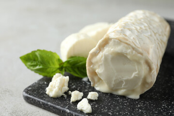 Delicious fresh goat cheese on black board, closeup