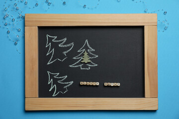 Flat lay composition with chalkboard, words Winter Break and Christmas decor on light blue background. School holidays
