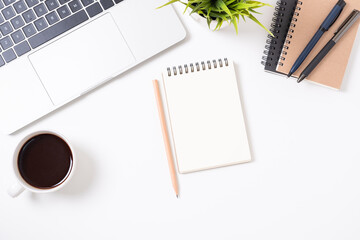 Flat lay of White office desk table or workplace with laptop, and coffee cup with equipment other office supplies with copy space, top view