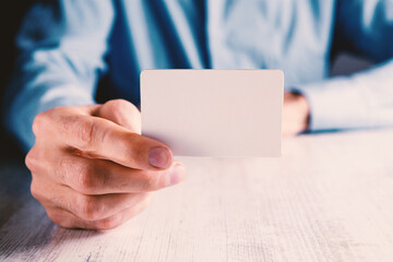 man holding a small paper in his hand