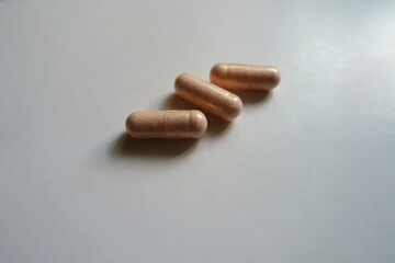 Closeup of three pink capsules of probiotic dietary supplement
