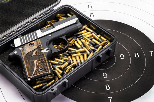 Automatic pocket gun and bullets  in box on bull eye target background