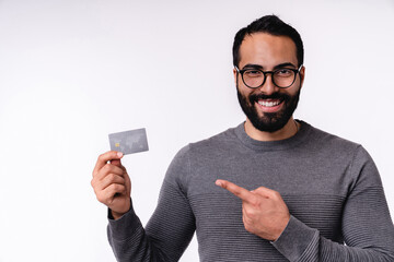 Handsome smart Arab man pointing at credit card in casual clothing isolated over white background