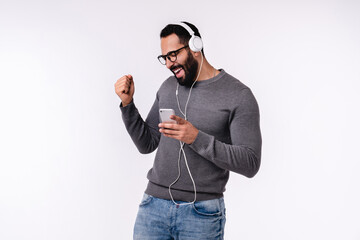 Handsome sporty Arab man listening to the music in casual attire isolated over white background