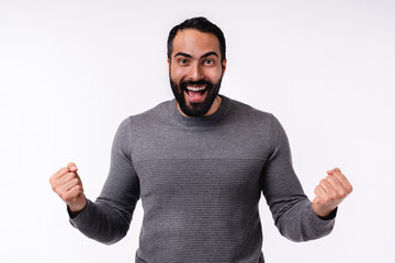 Happy excited young Arabian man in casual attire isolated over white background