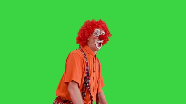 Funny clown rushing somewhere walking fast, almost running on a Green Screen, Chroma Key.