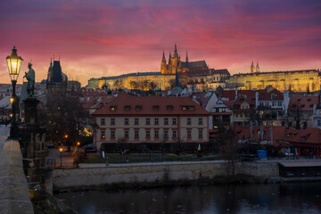 Fototapeta premium lamp at charles bridge and st. vita church lights from street lights are reflected on the surface of the vltava river in the center of prague at night in the czech republic