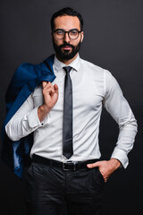 Vertical shot of a successful young arabian businessman isolated over black background