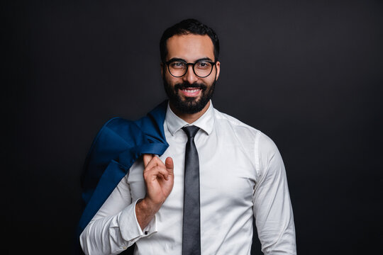 Happy confident arab businessman in office clothes isolated over black background