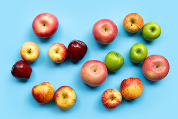 Variety of apples on blue background. Top view