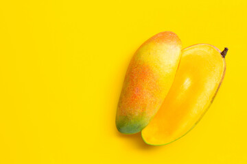 Ripe mango on yellow background. Copy space