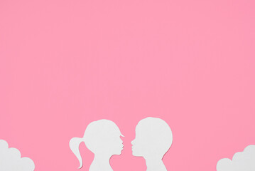 Obraz na płótnie Canvas Flat lay paper silhouette of couple girl and boy. Festive pastel pink background top view, copy space