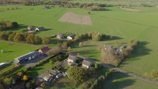 Aerial drone shot of tilling up over the countryside and big farm fields in the Netherlands.