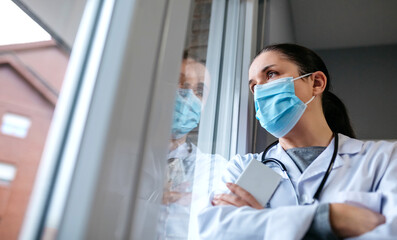 Self confident female doctor looking out the hospital window
