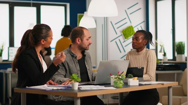 Team of diverse startup company colleague entrepreneur meeting in professional workplace, brifing and sharing ideas over financial strategy management. Multiracial business people working together.