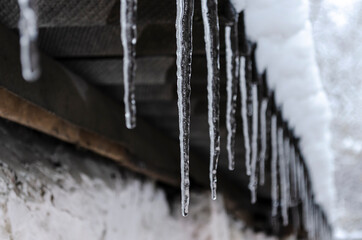 Icicles on the roof of old wooden house