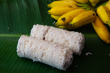 Popular Steamed Kerala Breakfast Dish served in banana leaf with yellow banana, puttu and yellow small banana served in banana leaf