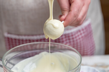 the making of cake pops with a melted chocolate coating