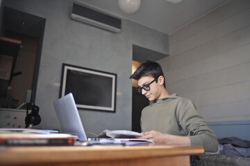 young boy studies in his room