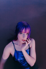 beautiful caucasian girl with dyed hair closeup photo lying relaxed on a salt lake with purple colors and natural light 