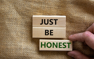 Just be honest symbol. Concept words 'Just be honest' on wooden blocks on a beautiful canvas background. Businessman hand. Business and just be honest concept. Copy space.