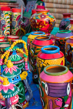 Beautiful painted colorful terracotta pots, works of handicraft, for sale during Handicraft Fair in Kolkata. Vertical image.