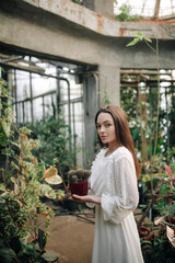 Woman takes care of potted cactuses.