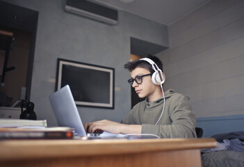 young boy studies in his room