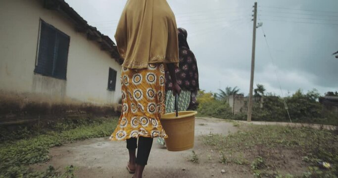 two black women carrying water in africa ghana