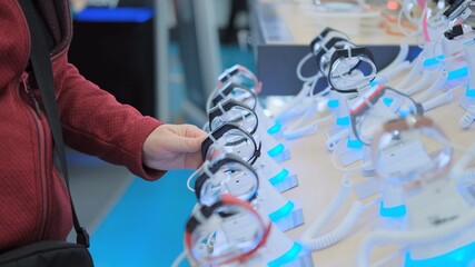 Women hands choose wrist watches in the store. There are many colorful high-tech watches on the...